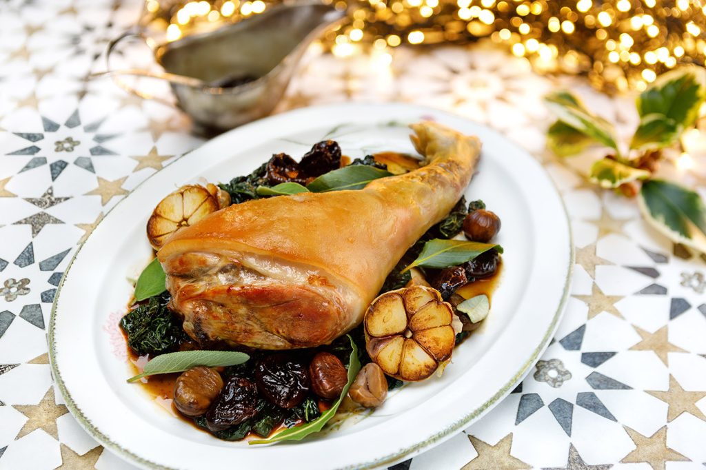 Roast Suckling Pig Leg with Cavolo Nero, Chesnuts, Prunes and Brandy Sauce